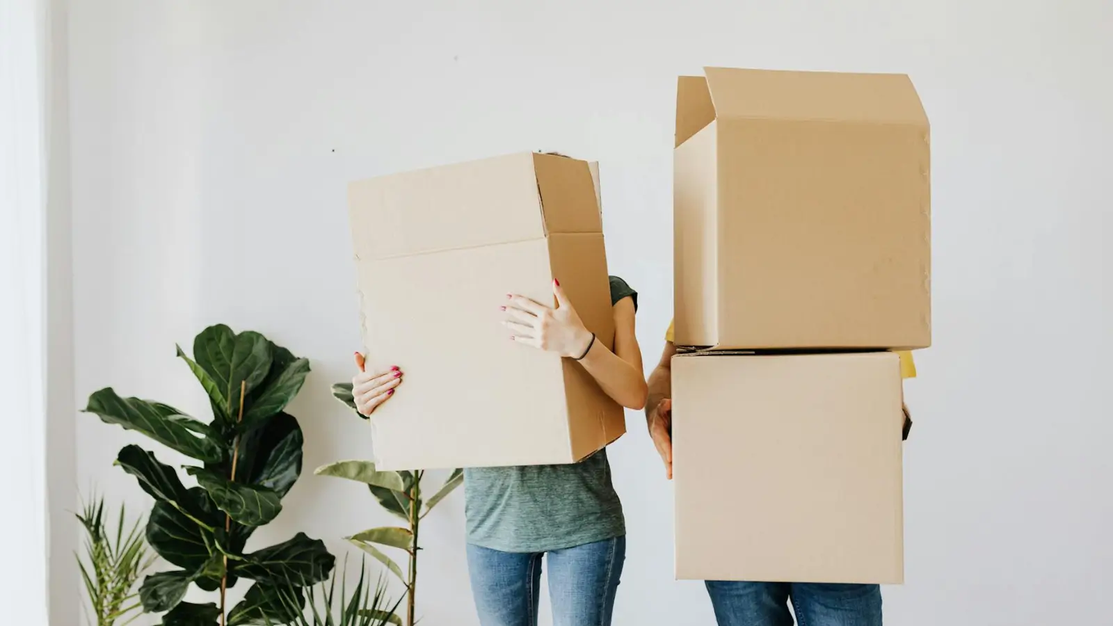 People carrying moving boxes during a home relocation, representing move-in and move-out cleaning services in San Diego.