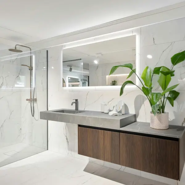 Bright bathroom with marble tiles, clean mirrors, and green accents — showcasing professional bathroom cleaning in San Diego.