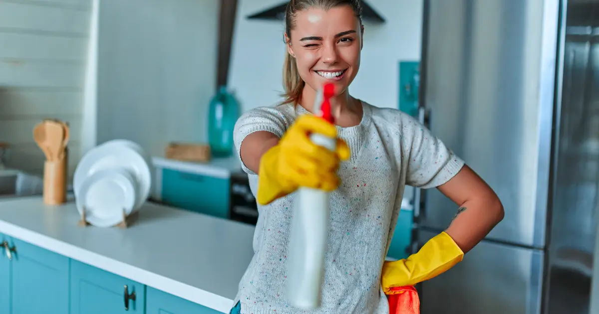 Busy professional cleaning the kitchen while using quick cleaning tips and holding a spray bottle