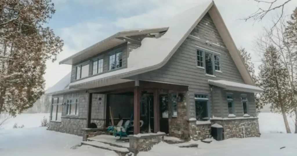 Snow-covered home exterior showing a house prepared for winter, highlighting the importance of cleaning and winterizing before the cold months.