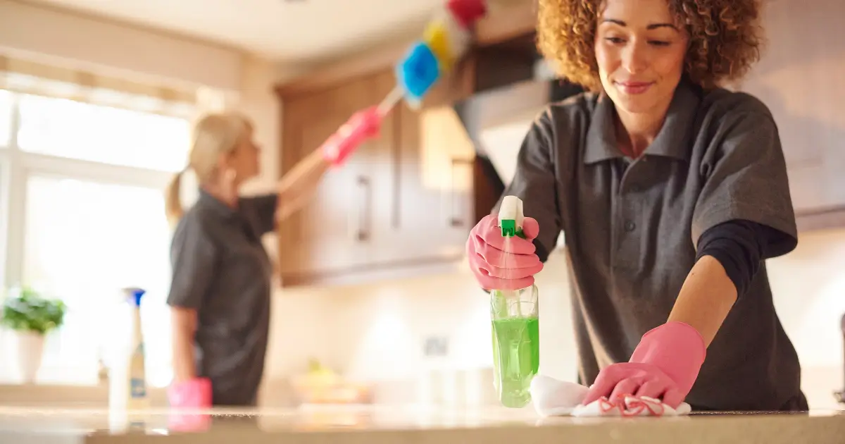 Professional cleaners wiping kitchen surfaces during a home cleaning service